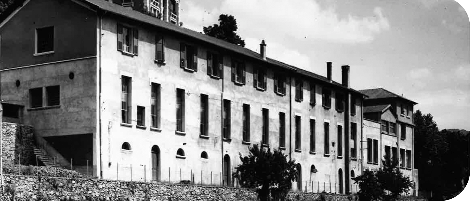 Ancien bâtiment industriel de plusieurs étages sur un coteau, photographie en noir et blanc